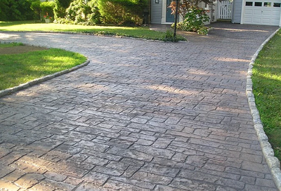 Concrete driveway made to look old and weathered with stamping and staining.
