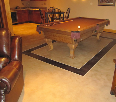 Residential home bar with pool table setting on decorative concrete.