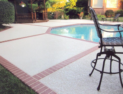 Pool deck with textured concrete and brick stamped edges.