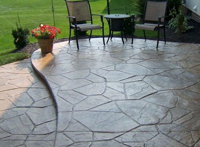 Bi-leveled stamped concrete patio with decorative stone design.